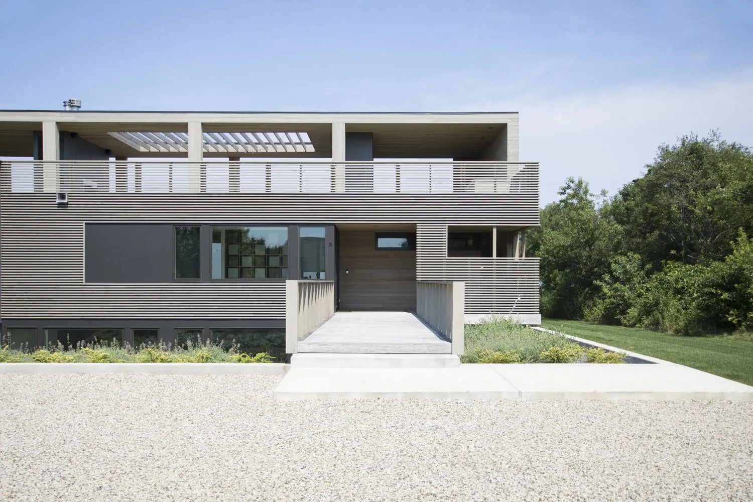 Modern two-story house with a gray exterior and large windows.