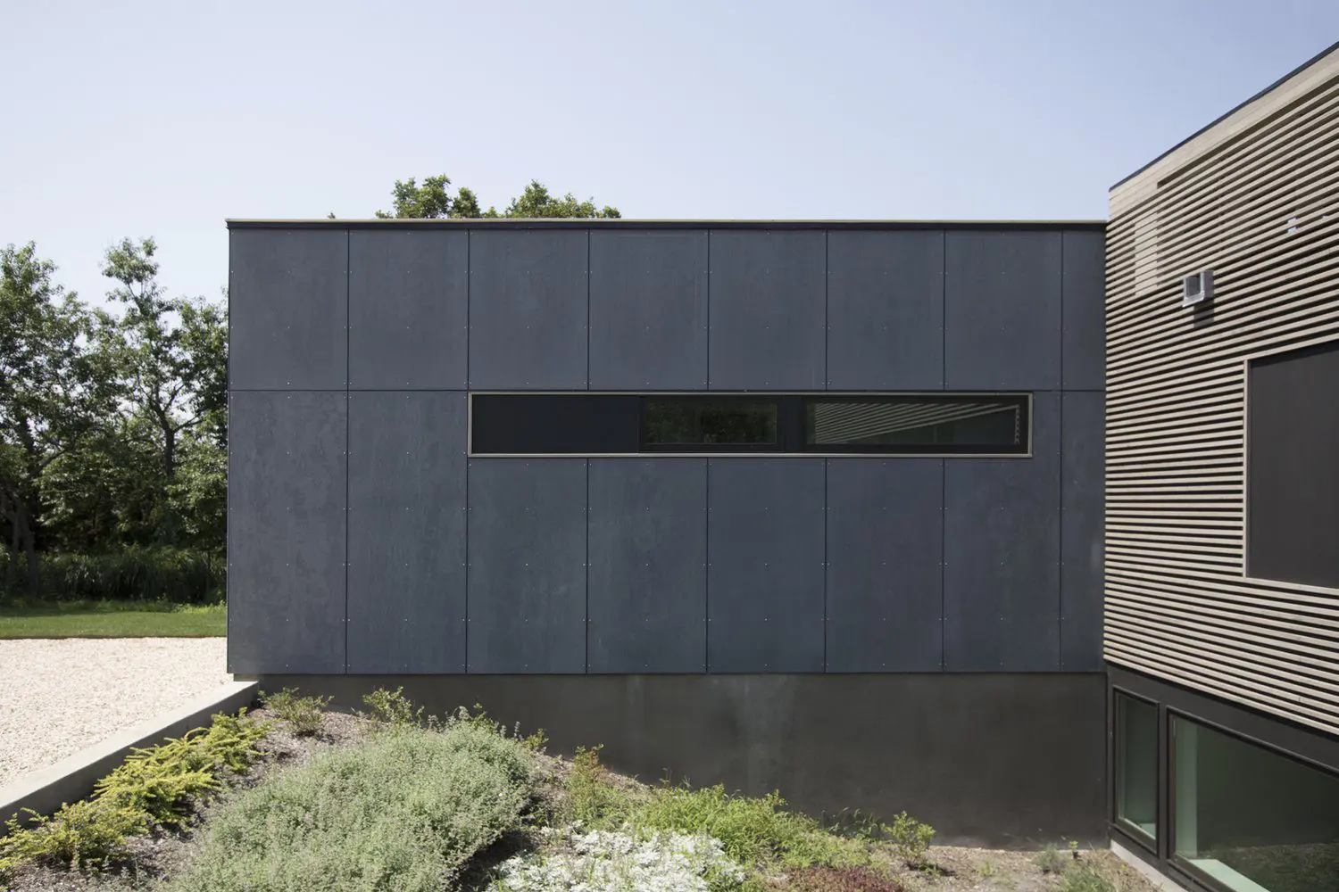 Modern gray building with a narrow horizontal window and minimalist design.
