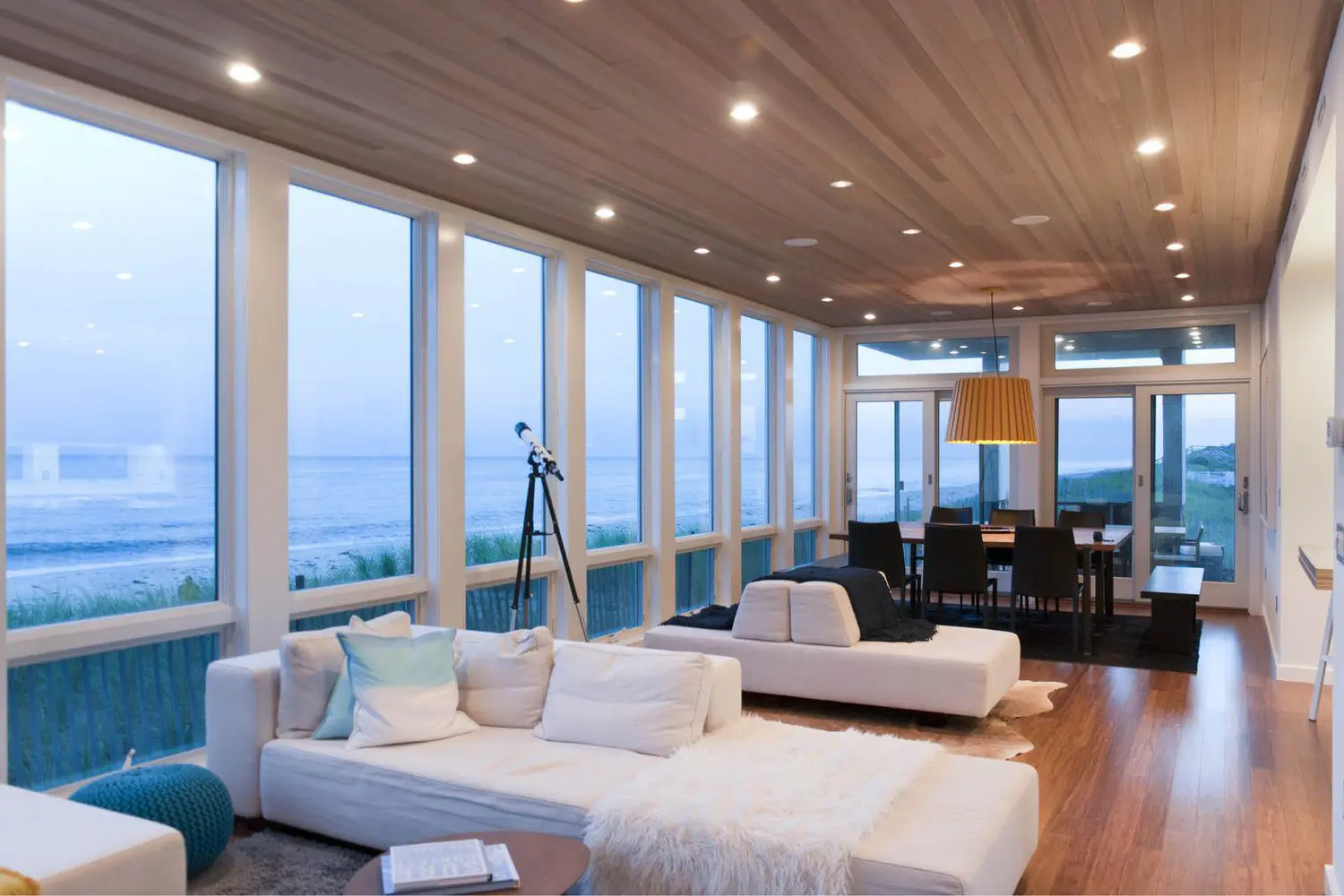 Modern living room with ocean view and telescope.