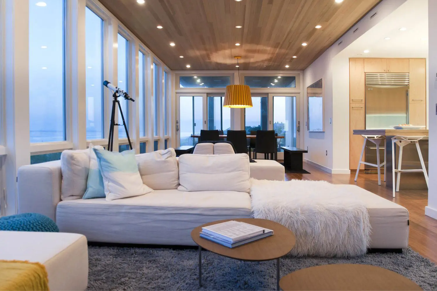 Modern living room with large windows and cozy seating.