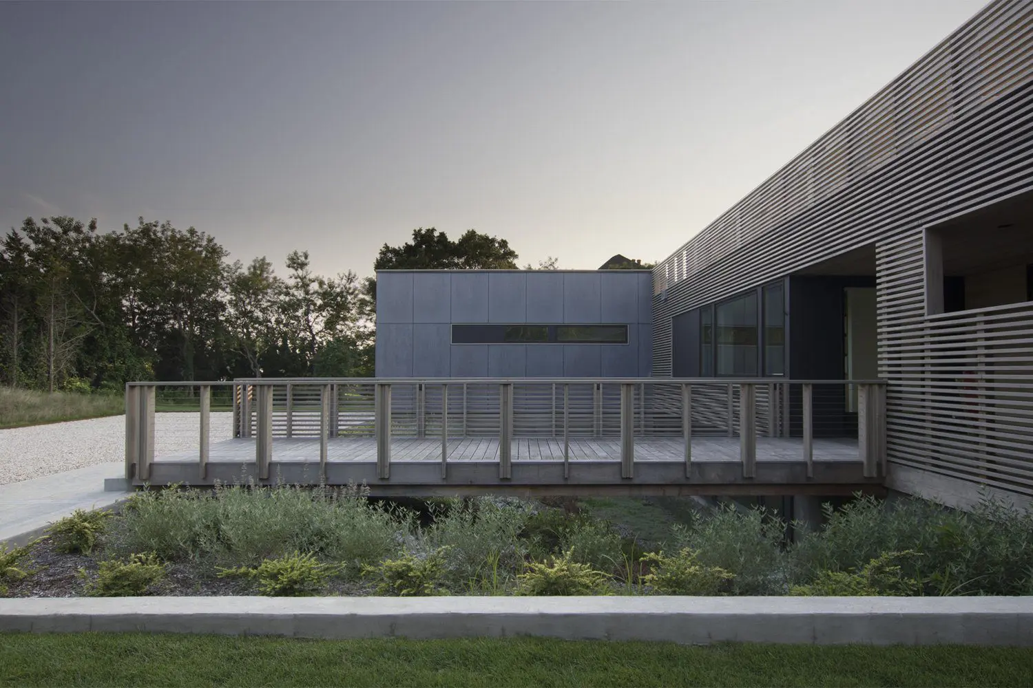 Modern building with clean lines and a glass railing at dusk.