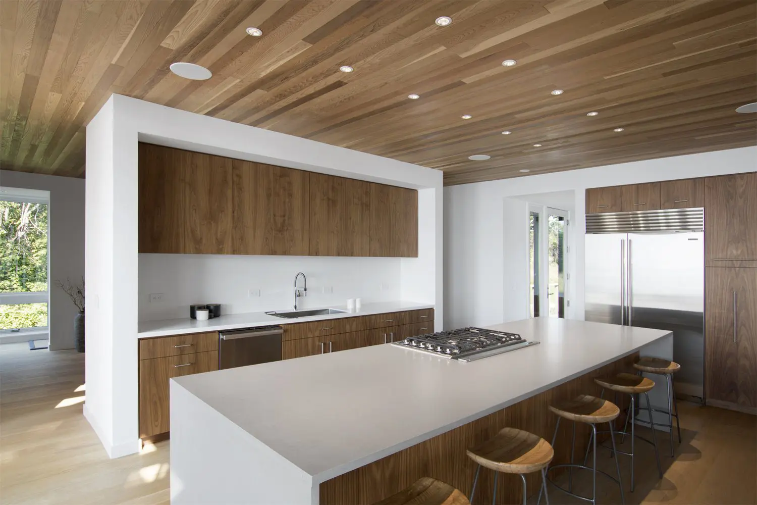 Modern kitchen with wooden cabinets and a white island with stools.