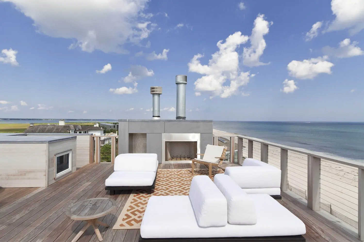 Oceanfront rooftop deck with white chaise lounges