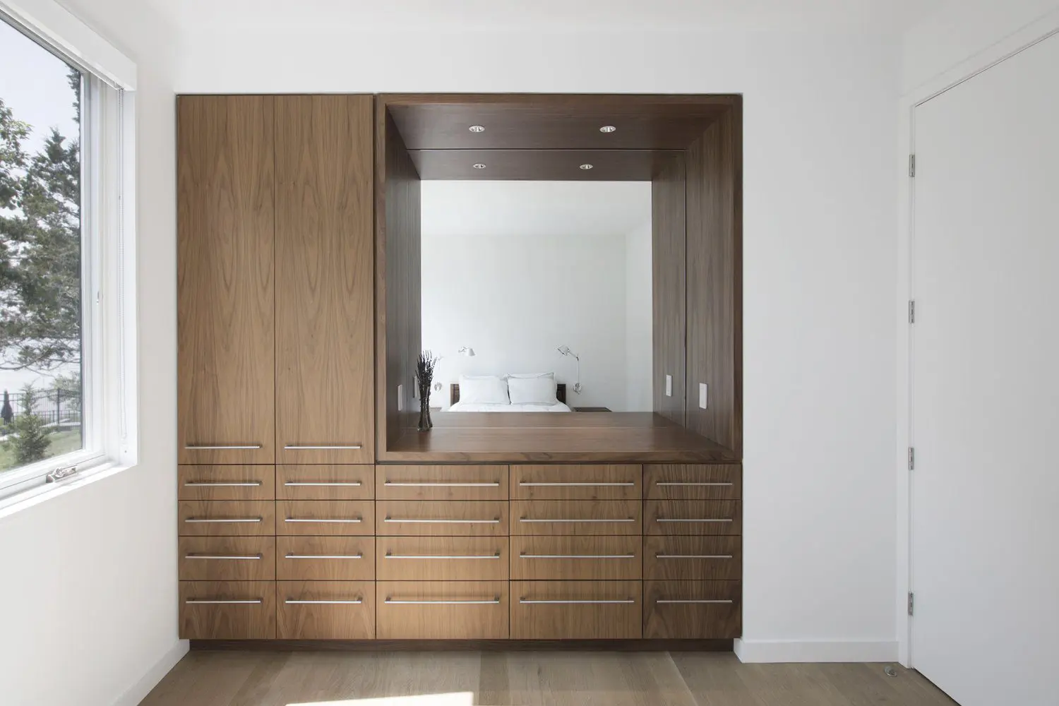 Modern wooden dresser with a mirror and minimalist decor.
