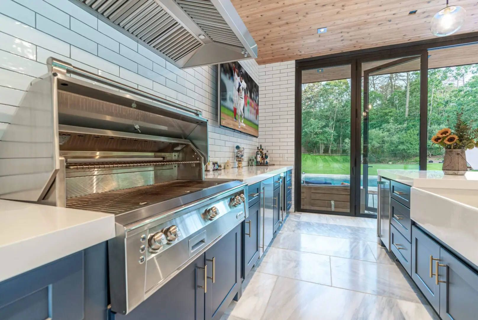 Modern kitchen with sleek appliances and large glass doors opening to a garden.