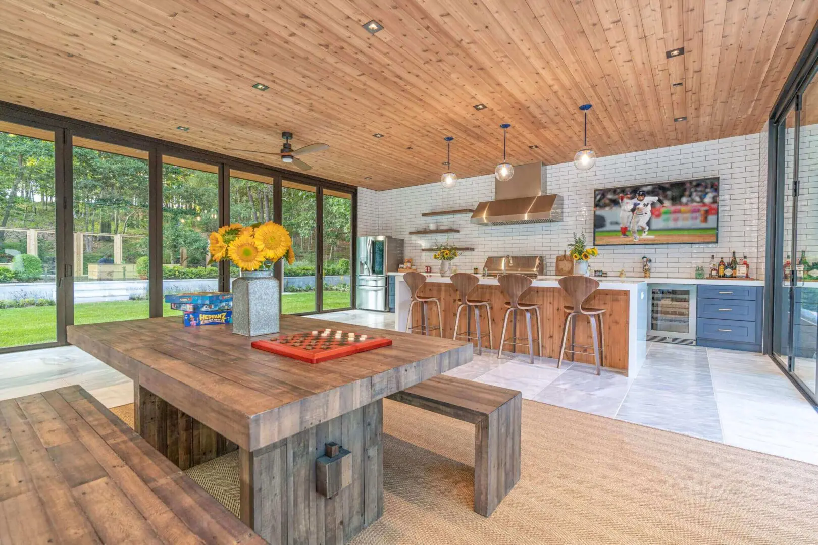Rustic dining area with wooden table, benches, and a modern kitchen in the background.