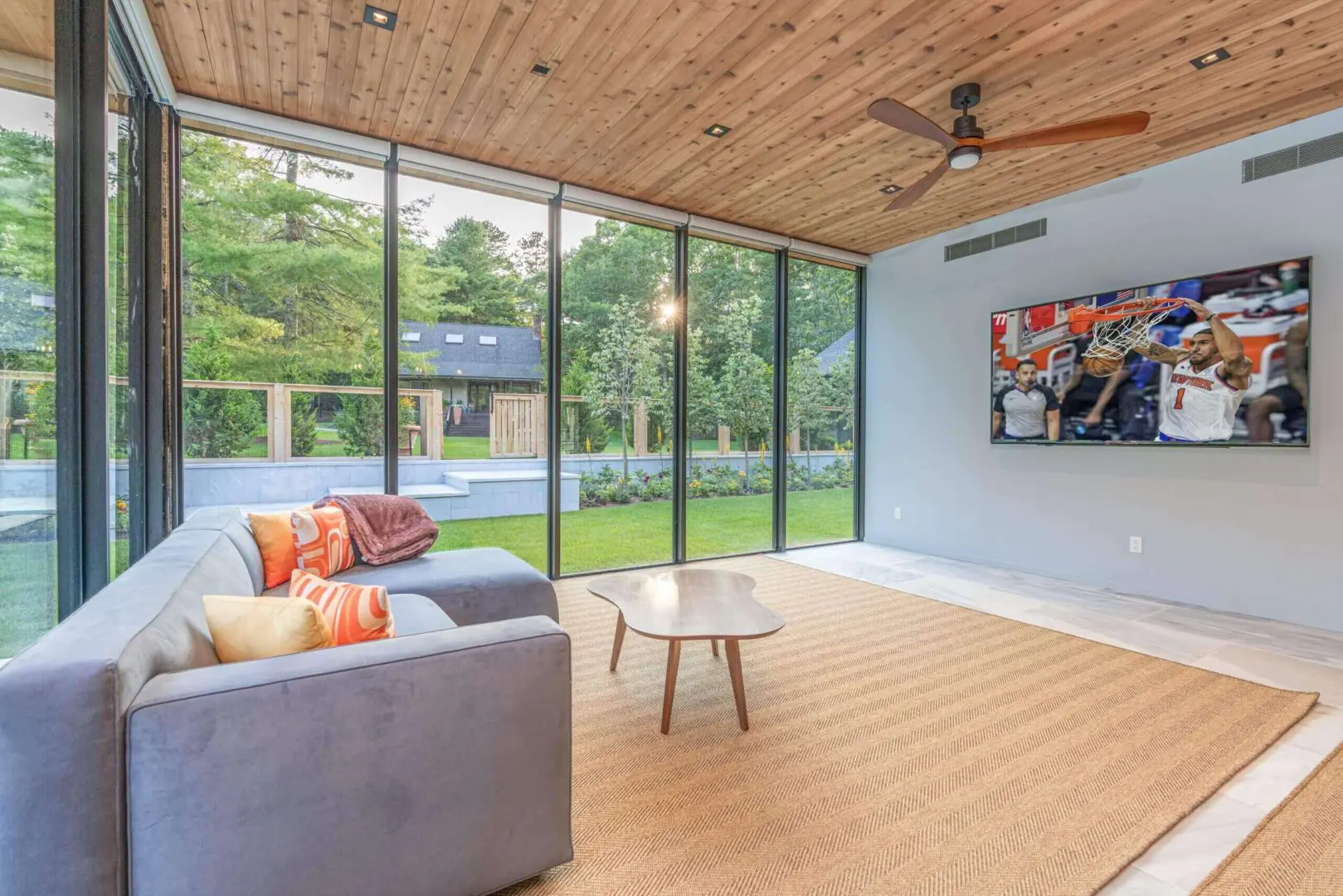 Modern living room with large glass windows and cozy seating.