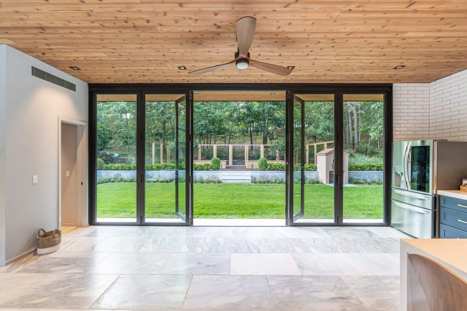 Modern room with large glass sliding doors opening to a green garden.