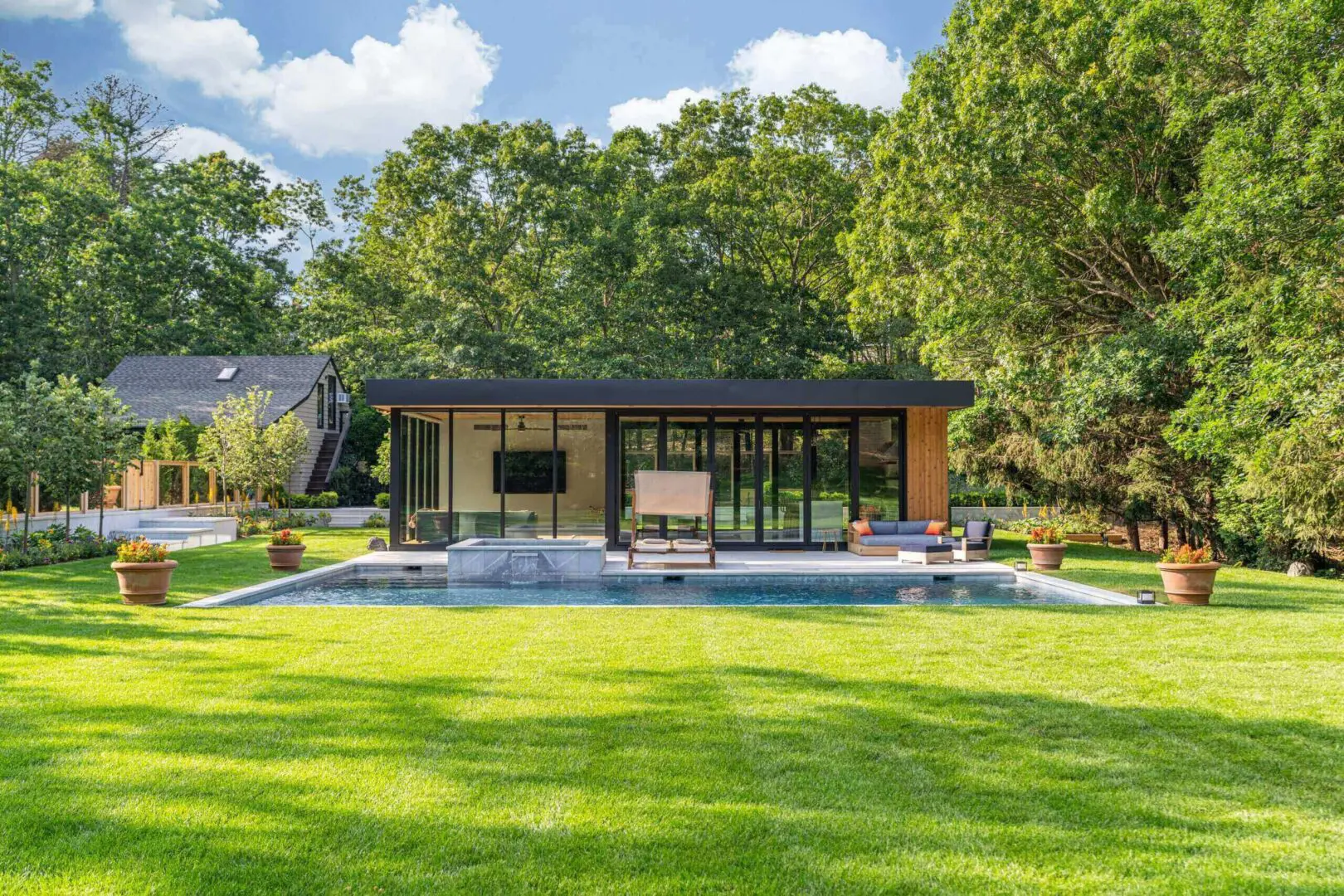 Sleek pool house facing open green lawn