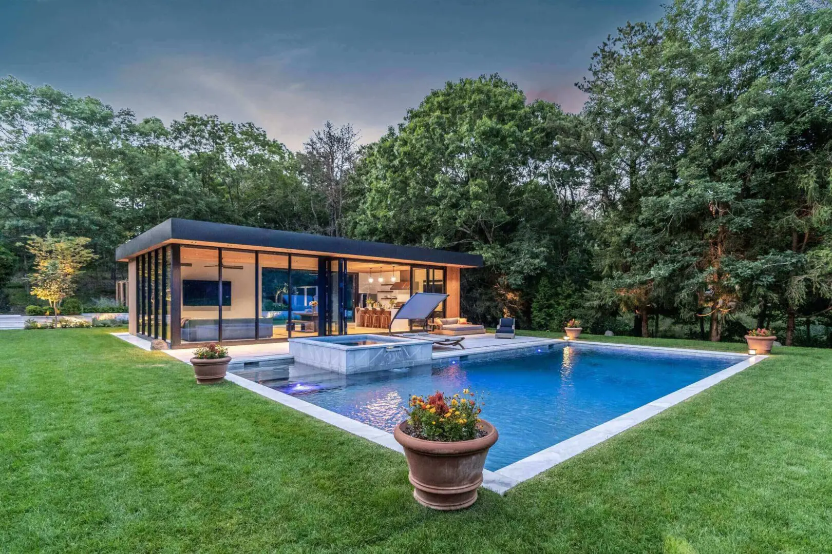 Modern house with a pool surrounded by greenery.