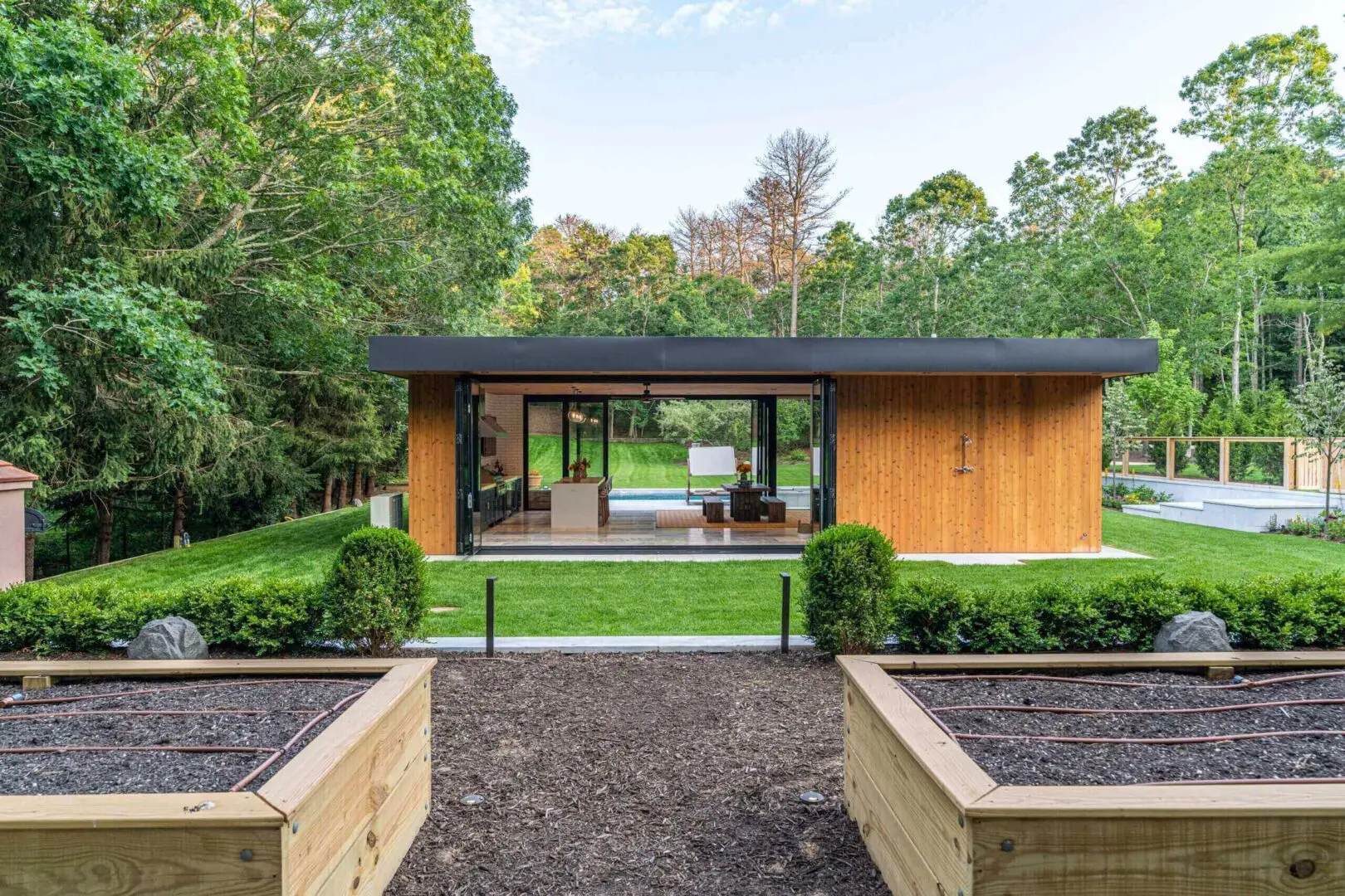 Raised garden beds facing glass pool pavilion