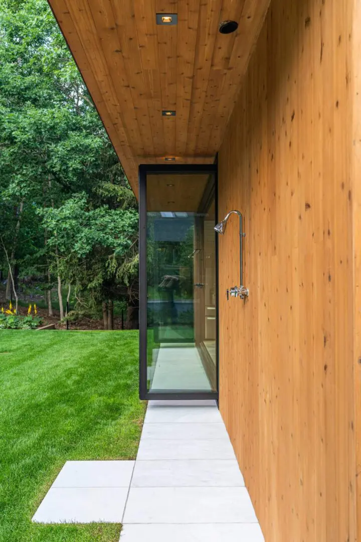 Wood-clad pool house with glass door and shower