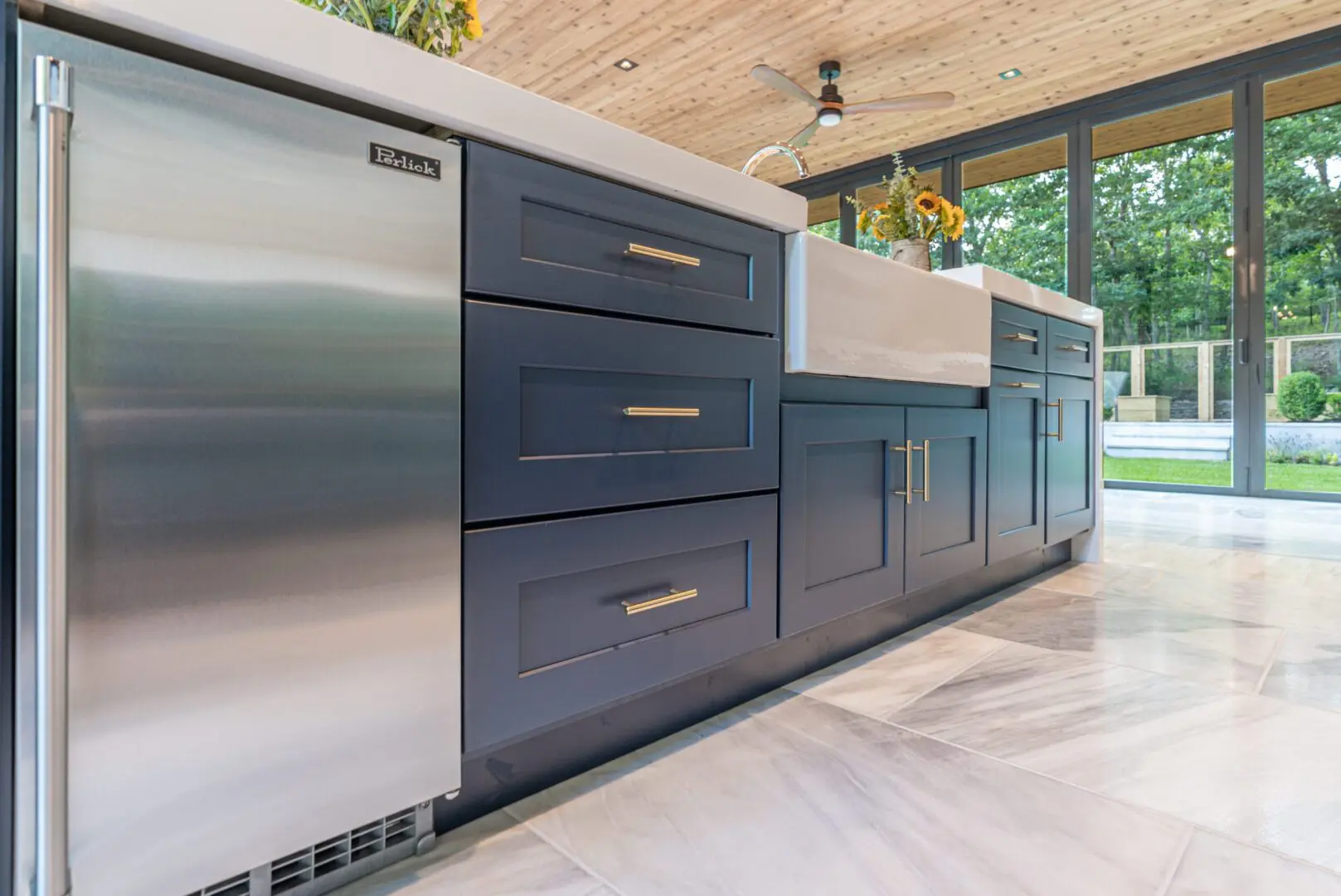 Modern kitchen island with navy blue cabinets and brass handles.