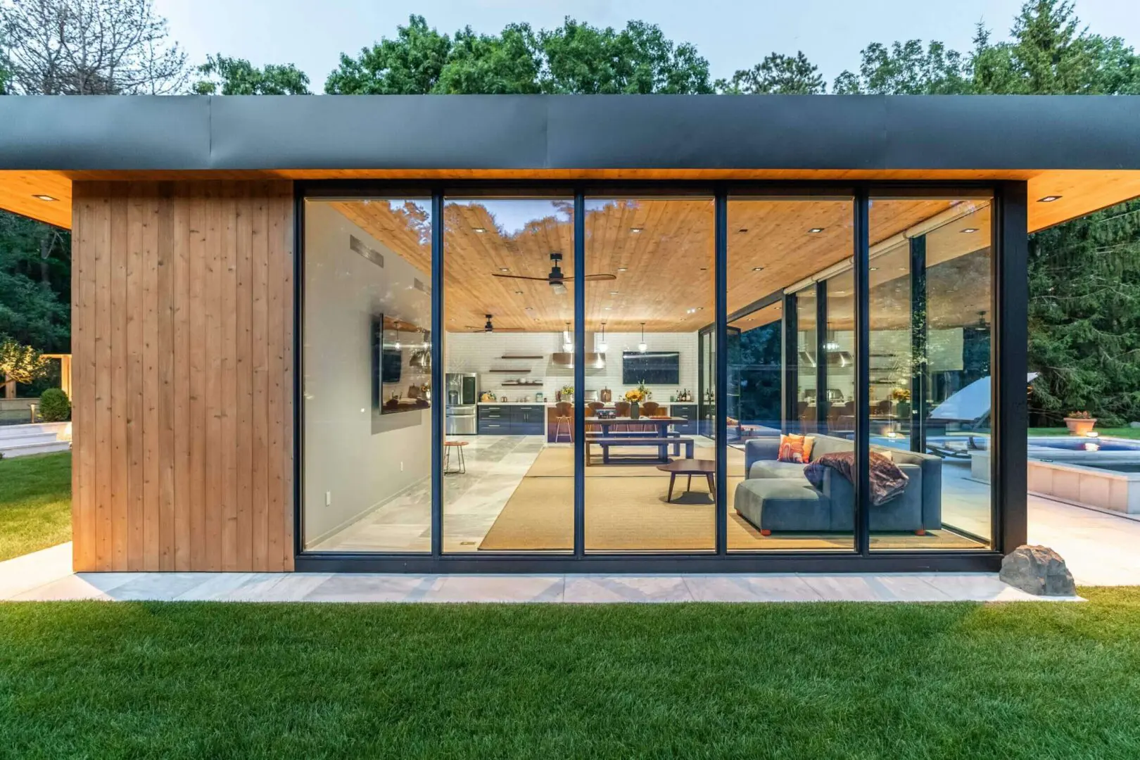Modern home with large glass sliding doors and wooden exterior.