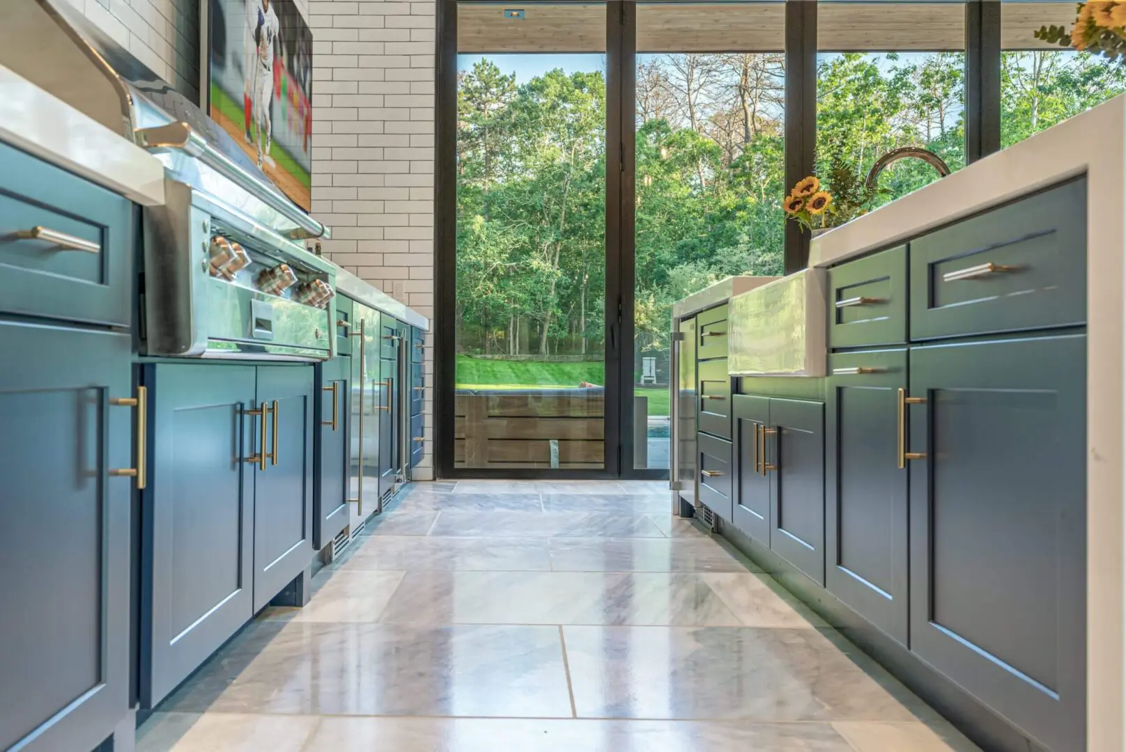 Modern kitchen with sleek grey cabinets and large windows.