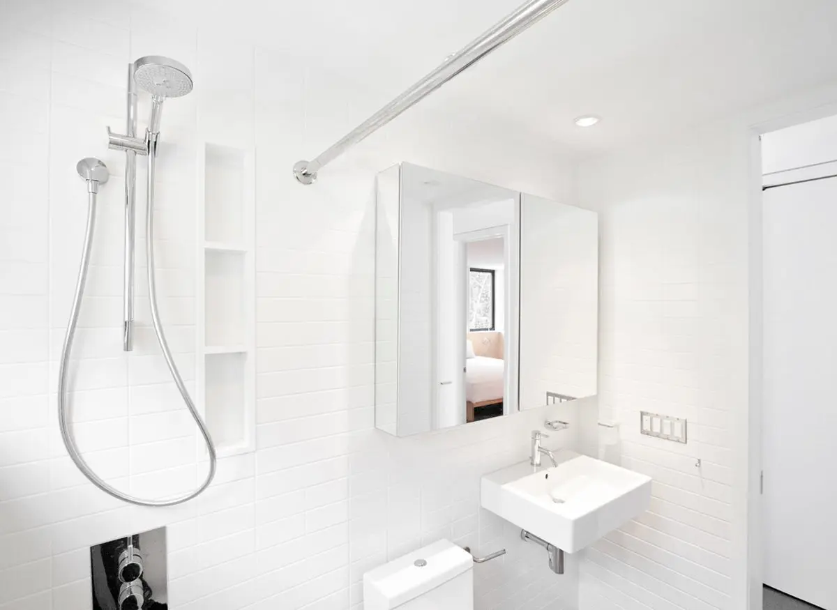 Bright, modern all-white bathroom with shower and sink.