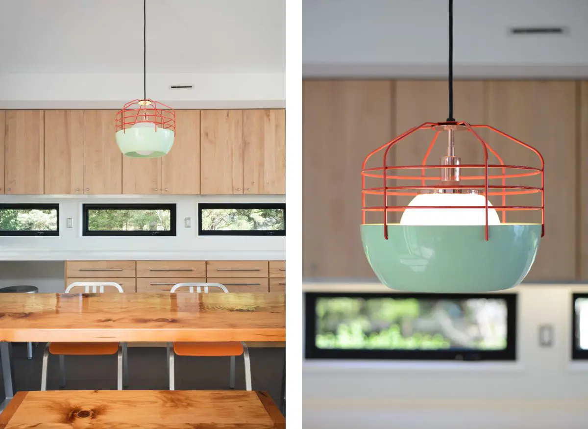 Modern dining area with wooden bench and unique pendant light fixtures.