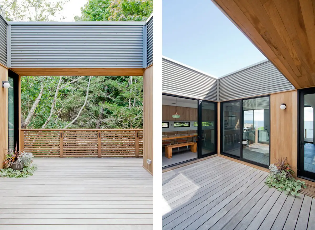 Modern outdoor deck area with wood flooring and glass walls.
