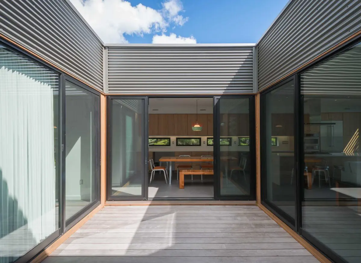 Modern courtyard with glass doors and wooden deck flooring.