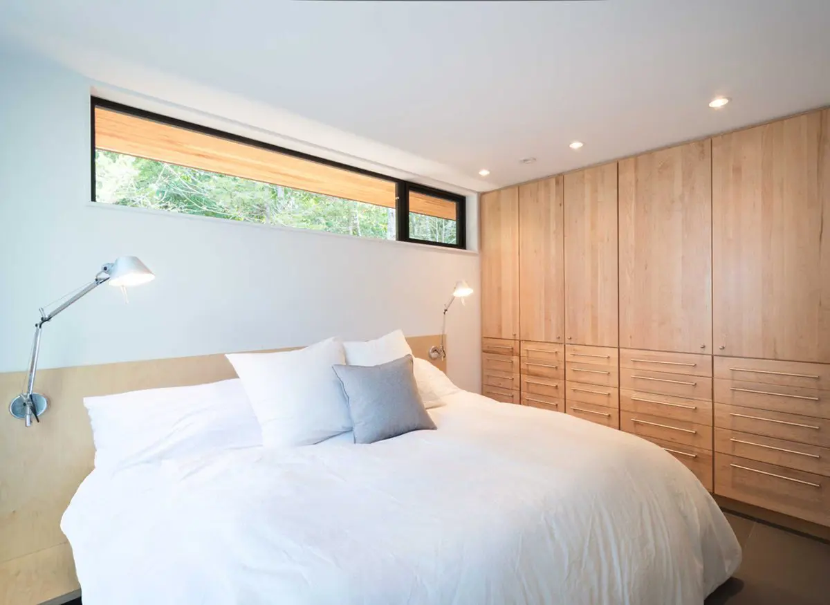 Bright bedroom with wooden accents and white bedding.