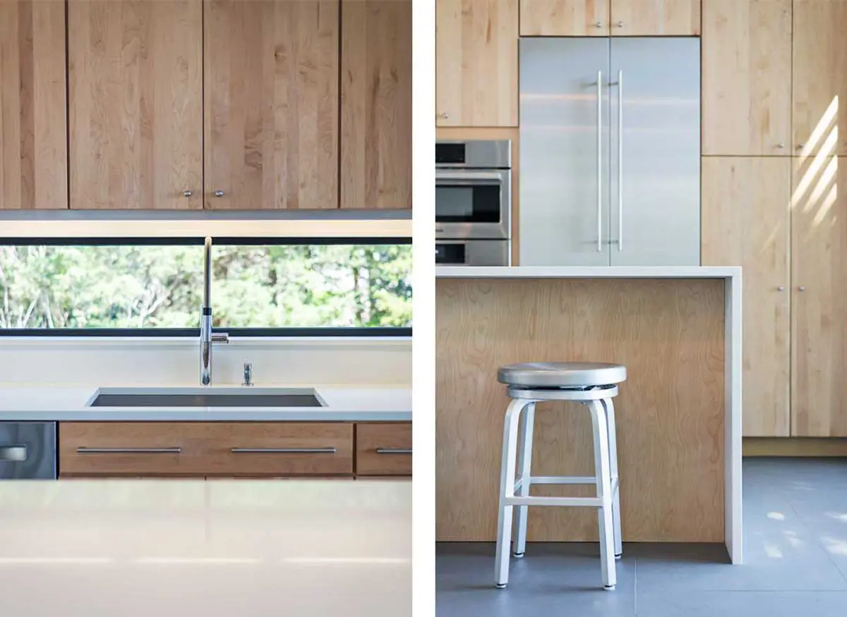 Modern kitchen with wood cabinetry, a sleek sink, and a stainless steel stool.