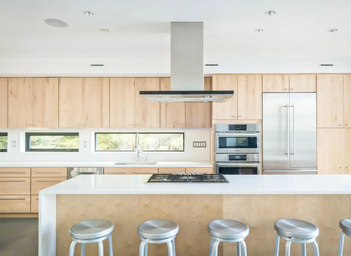 Modern kitchen with wooden cabinets and a large island with stools.