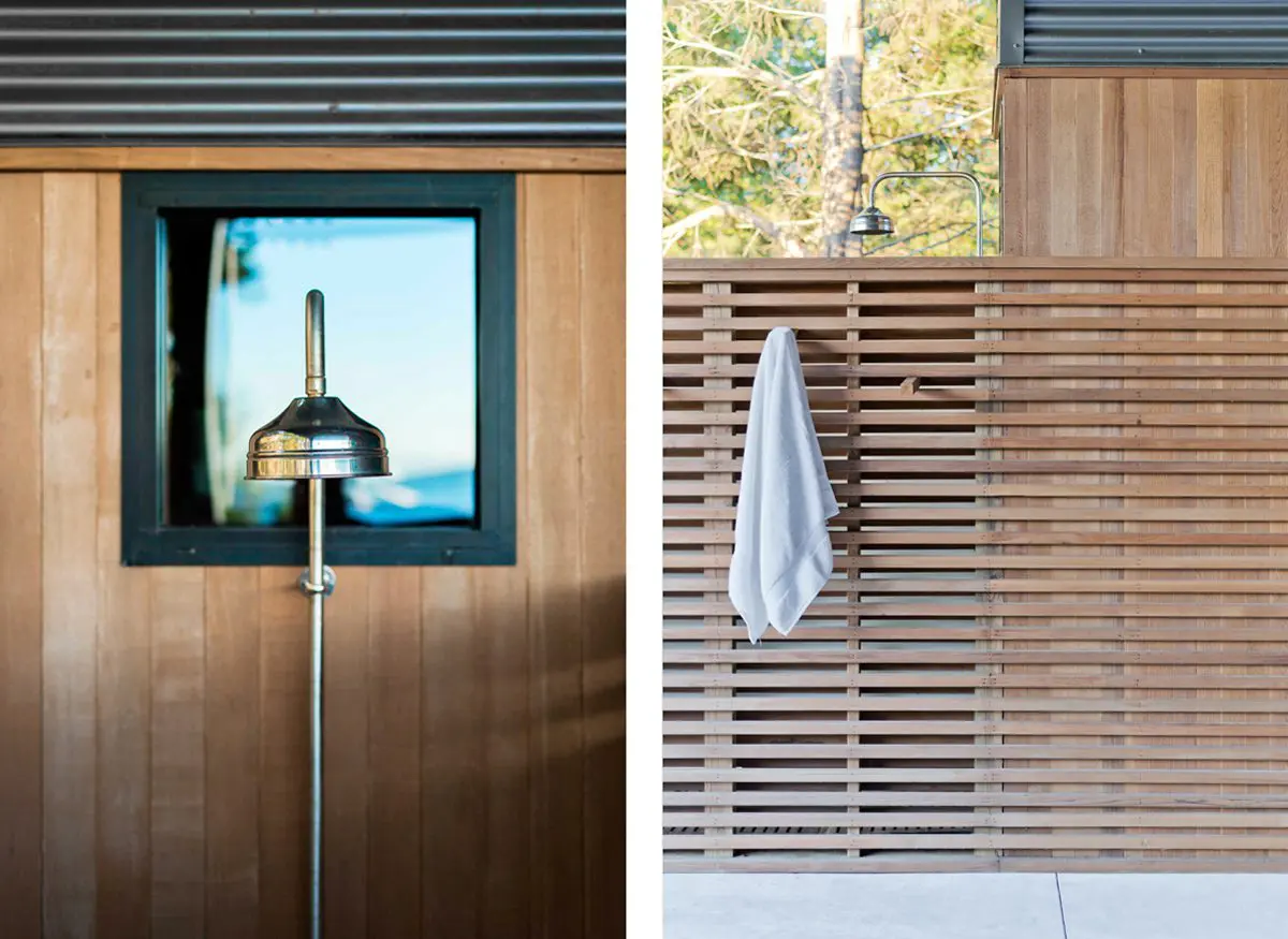 Modern outdoor shower with wooden slats and a towel hanging.