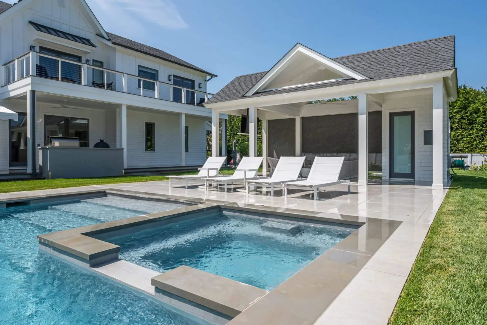 Modern backyard with pool and lounge chairs by a stylish house.