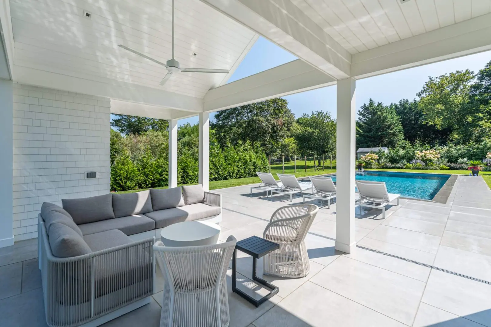 Modern outdoor patio with comfortable seating and a pool view.