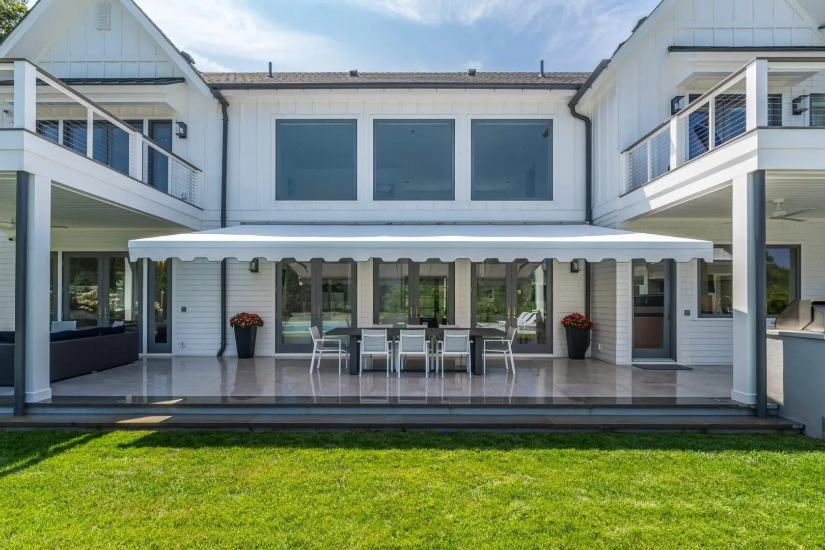 Modern white house with a spacious patio and green lawn.