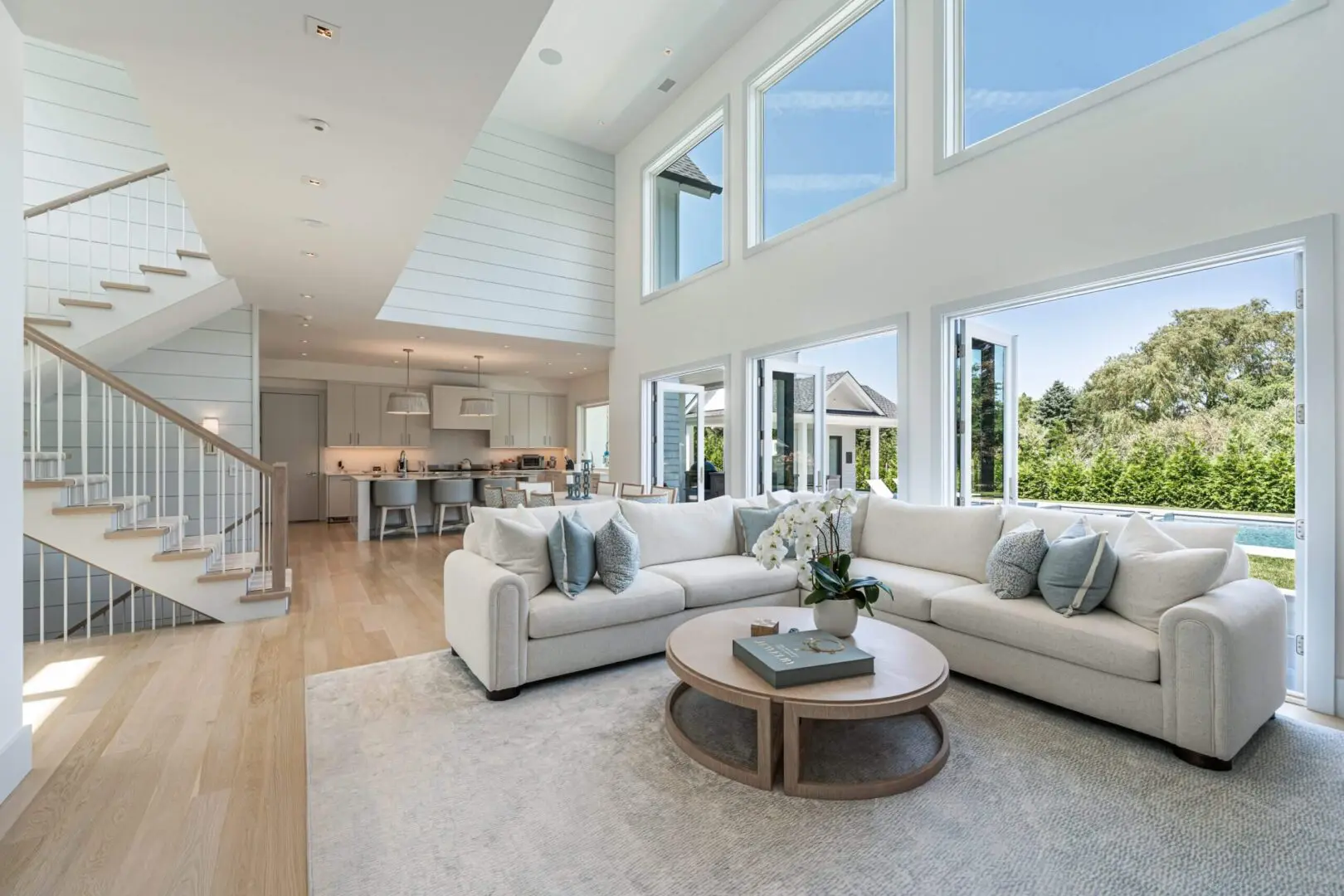 Bright modern living room with large windows and cozy seating.