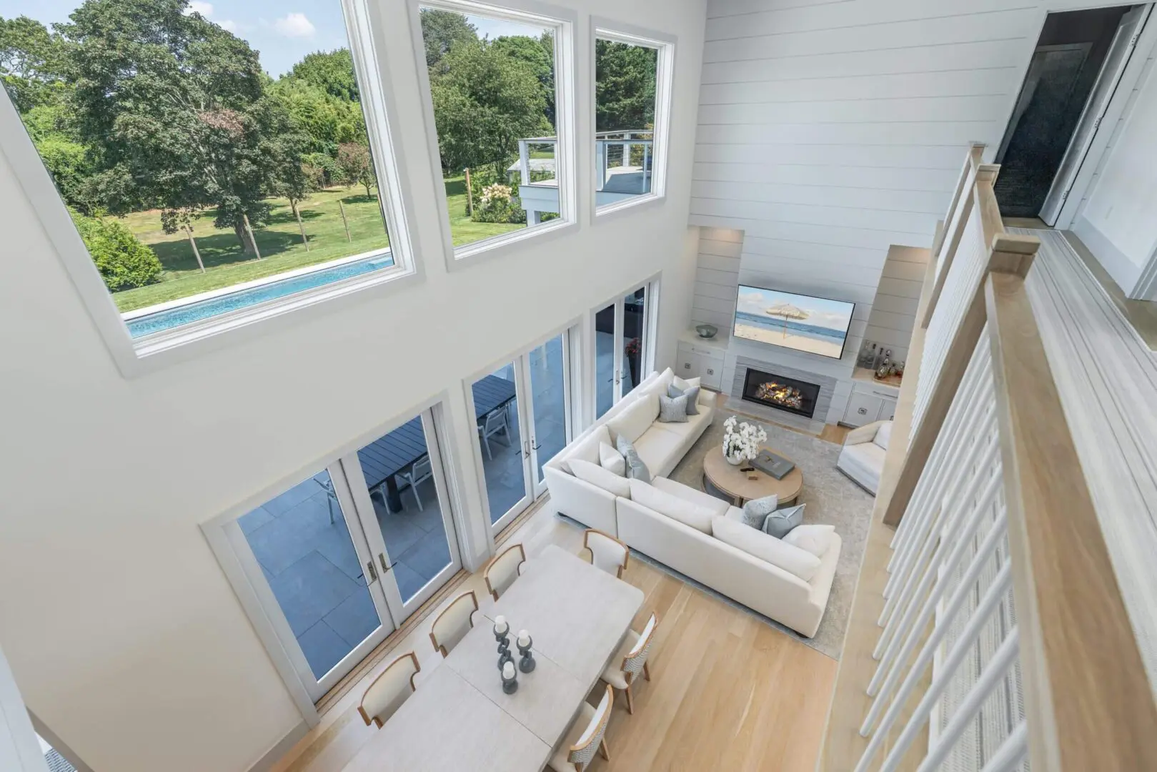 Bright modern living room with large windows and cozy fireplace.