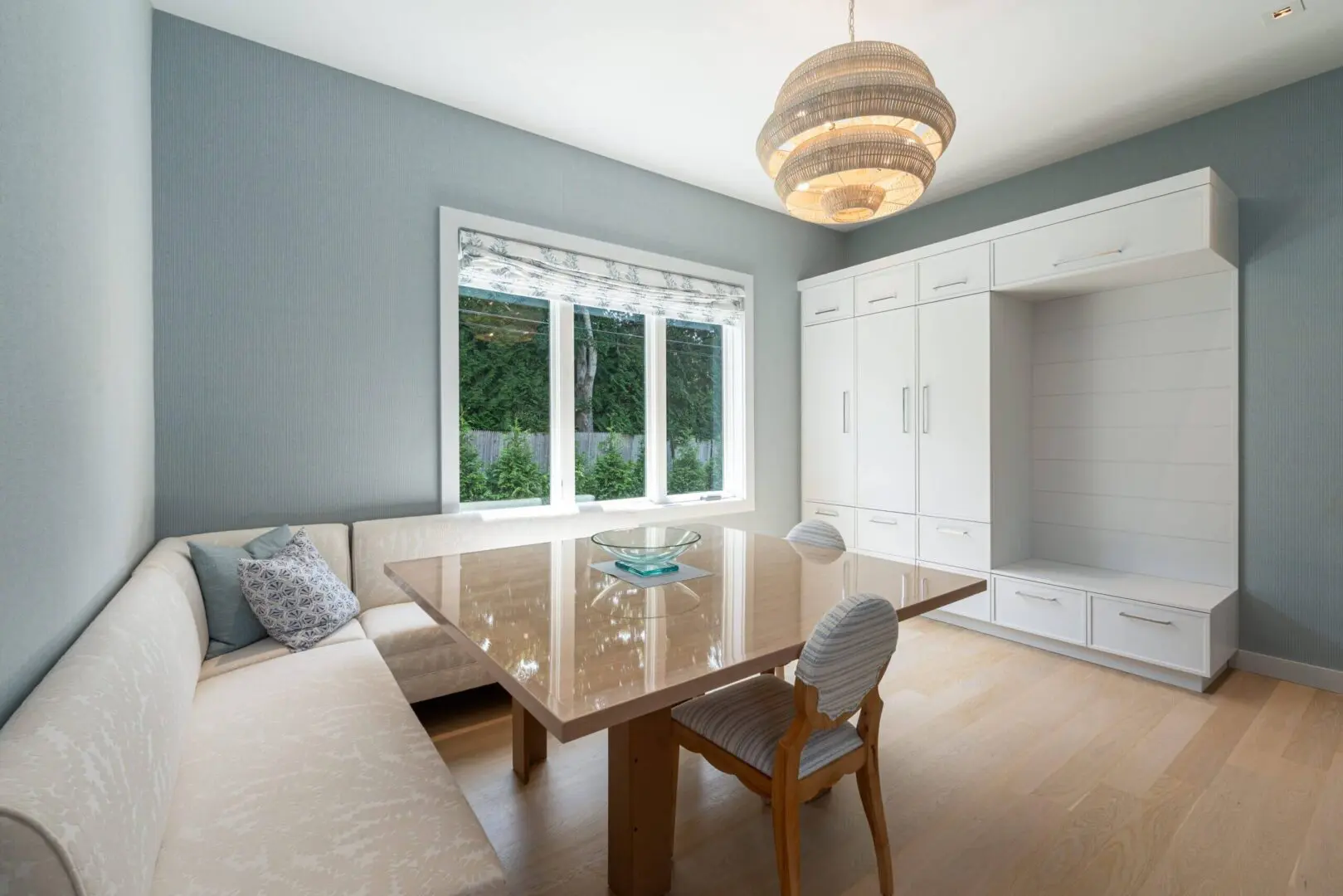 Bright dining area with large window and modern furnishings.