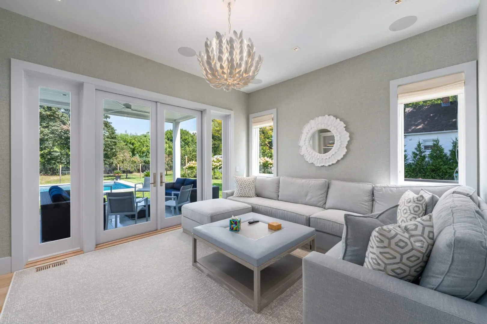 Modern living room with gray sectional sofa and chandelier.
